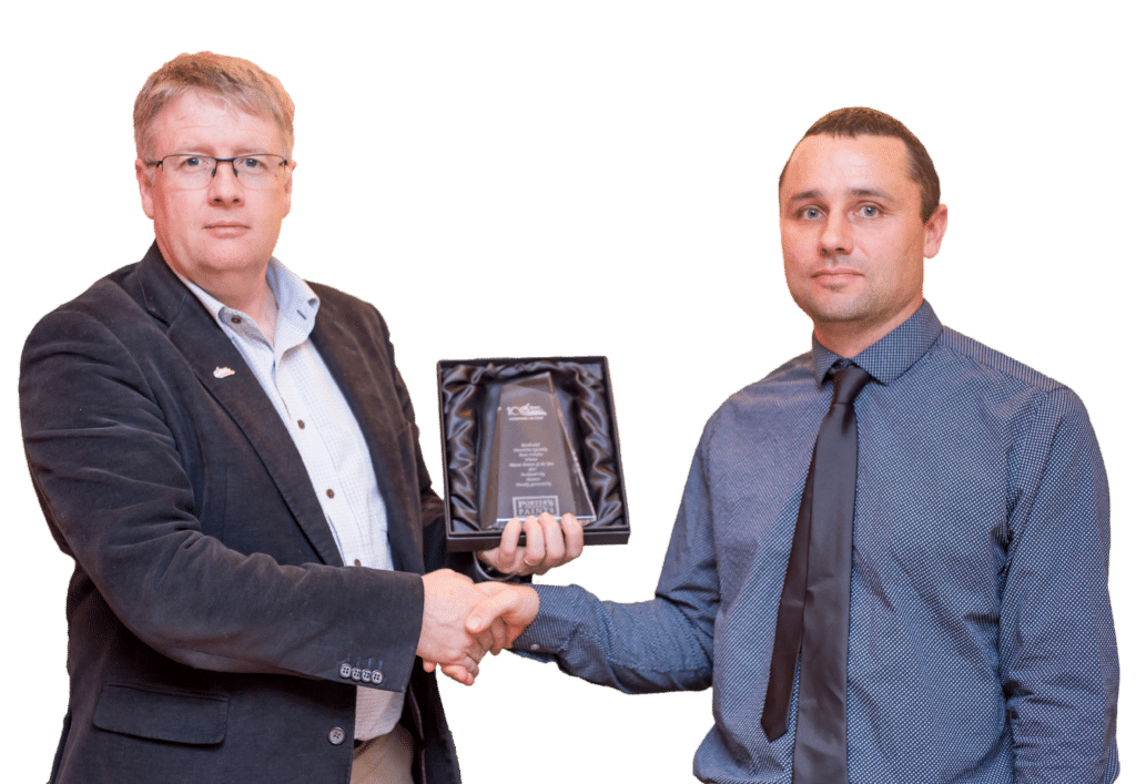 Head of Master Painters New Zealand on left holding out an award trophy and shaking hands with John Pujol, Director of Auckland City Painters on right